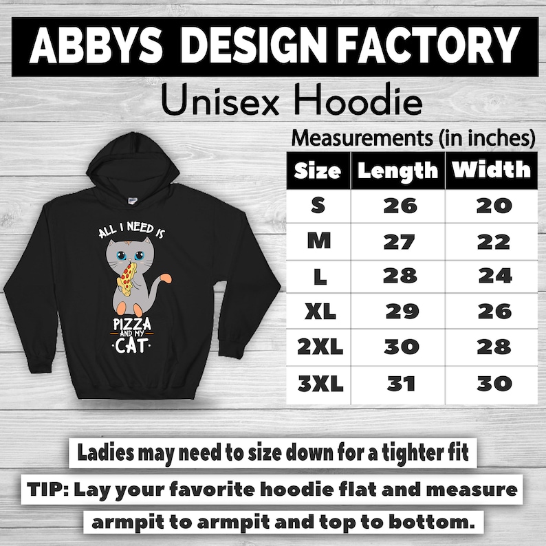 May include: Black unisex hoodie with a graphic of a gray cat holding pizza and the text "ALL I NEED IS PIZZA AND MY CAT." The hoodie has a hood and a size chart with measurements in inches. The text "ABBYS DESIGN FACTORY" is at the top.