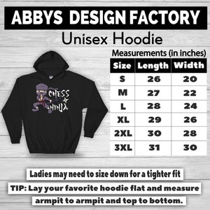 May include: Black unisex hoodie with a hood, featuring a cartoon ninja with the text "Chess Ninja." The hoodie has a size chart with measurements in inches. The brand name "ABBYS DESIGN FACTORY" is at the top.