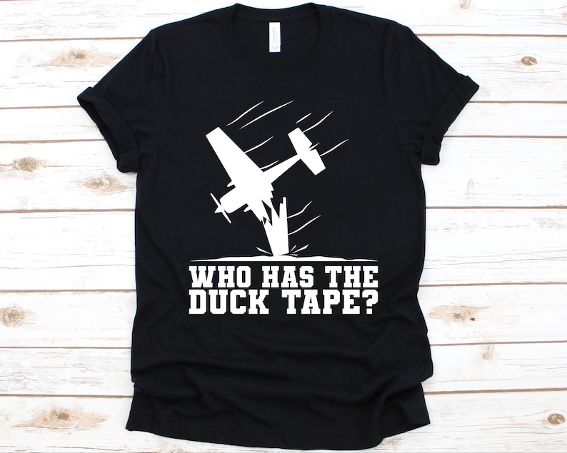 May include: Black t-shirt featuring a white graphic of a crashing airplane with the text "WHO HAS THE DUCK TAPE?" The design is a humorous take on aviation and repair.