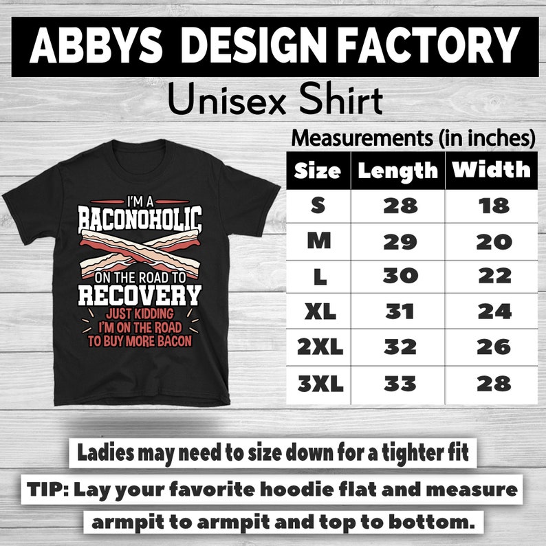 May include: Black unisex t-shirt with the text "I'M A BACONOHOLIC" and "ON THE ROAD TO RECOVERY" with bacon graphics. Includes a size chart with measurements in inches. The shirt is from Abbys Design Factory.