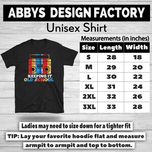 May include: Black unisex t-shirt featuring a retro boombox graphic in red, yellow, blue, and white, with the text "KEEPING IT OLD SCHOOL." Measurements chart in inches is also visible.