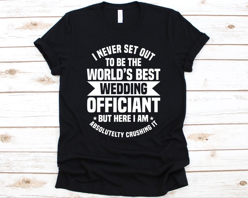 K&ouml;nnte beinhalten: Schwarzes T-Shirt mit wei&szlig;em Text. Der Text lautet: "I NEVER SET OUT TO BE THE WORLD'S BEST WEDDING OFFICIANT BUT HERE I AM ABSOLUTELY CRUSHING IT."