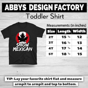 Pode incluir: Camiseta preta para crian&ccedil;a com um gr&aacute;fico de folha de bordo dentro de um c&iacute;rculo vermelho e branco, com o texto "SNOW MEXICAN". Medidas em polegadas para tamanhos 2T a 5T.