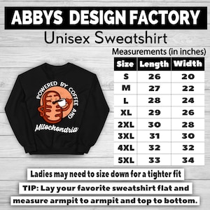 May include: Black unisex sweatshirt with the text "ABBYS DESIGN FACTORY" and "Unisex Sweatshirt". The sweatshirt features a graphic of a mitochondria holding a coffee cup with the words "POWERED BY COFFEE AND Mitochondria". Measurements are provided in inches.