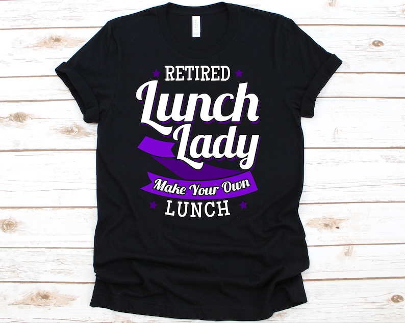 May include: Black t-shirt with the text "Retired Lunch Lady Make Your Own Lunch" in white and purple. The design includes a purple banner and star accents, perfect for a retired lunch lady.