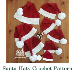 May include: A selection of red and white crocheted Santa hats, each with a white pom-pom, displayed on a wooden surface. The hats are of various sizes. The image includes the text "Santa Hats Crochet Pattern".