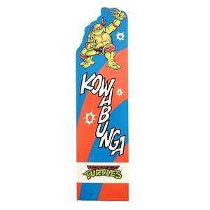 May include: A vertical Teenage Mutant Ninja Turtles graphic with a green turtle character holding weapons. The design features the words "Kowabunga" in white, with red and blue stripes and the Turtles logo.