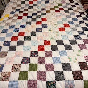 New Handmade Patchwork Quilt with white squares surrounded by so many different colors and patterns. Eye candy for fabric lovers. Queen size