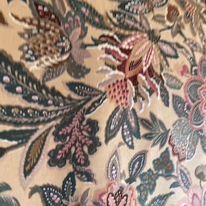 Puede incluir: Un primer plano de una tela con un patr&oacute;n floral. La tela es beige con flores marrones, rosas y verdes. Las flores son intrincadas y detalladas.