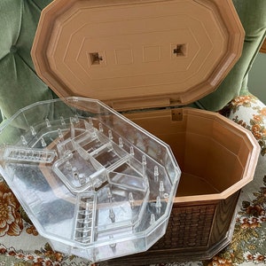 May include: A vintage octagonal-shaped wooden jewelry box with a clear plastic insert for storing jewelry. The box has a woven wood pattern and a brown lid.