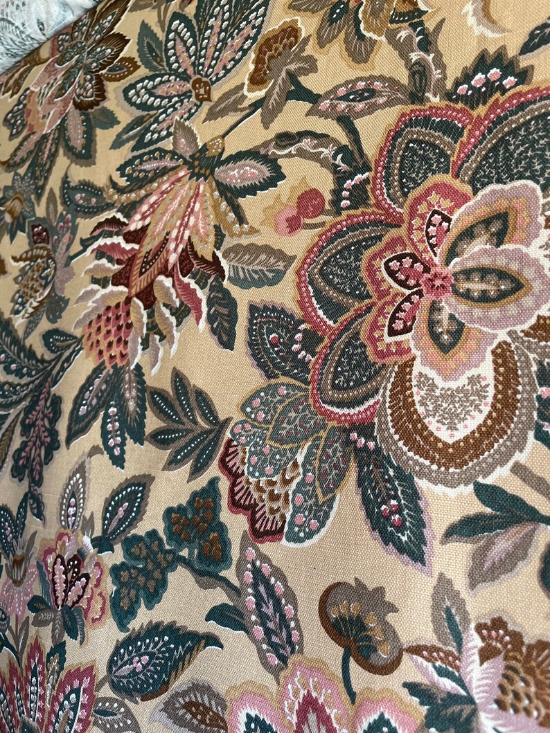 Puede incluir: Tela beige con un patr&oacute;n floral en tonos de rosa, marr&oacute;n y verde. El patr&oacute;n presenta flores, hojas y remolinos de diferentes tama&ntilde;os.