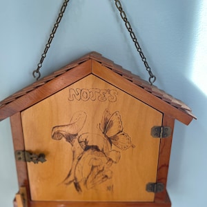 Bloc-notes vintage des années 1970 sur le thème des champignons et des papillons pour que vos invités puissent laisser un mot lorsque vous n'êtes pas à la maison.  Oeuvre d'art brûlée sur bois