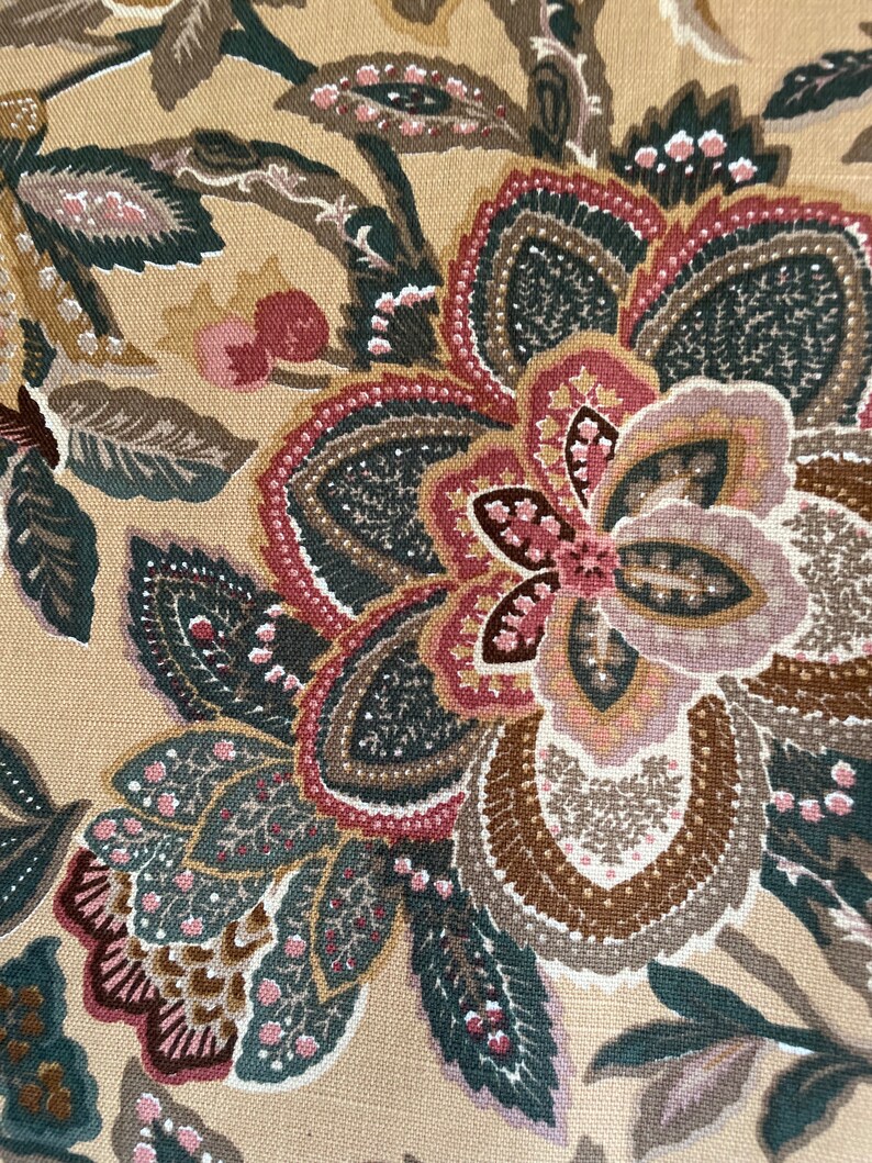 Puede incluir: Primer plano de una tela beige con un patr&oacute;n floral. El patr&oacute;n presenta una flor grande con p&eacute;talos marrones, rosados y grises. El fondo es de color beige claro.
