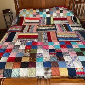 Gorgeous Scrappy handmade Quilt with lots of vintage pretty fabrics hand quilted & finished with triangle points around the quilt  92”x85”