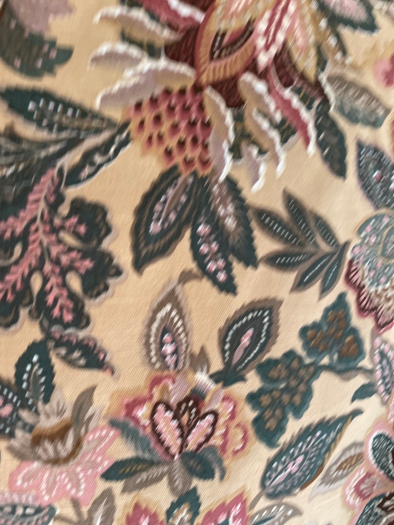 Puede incluir: Una tela beige con un patr&oacute;n floral en tonos de rosa, marr&oacute;n y verde. El patr&oacute;n presenta flores y hojas estilizadas.