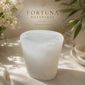 Puede incluir: Un molde de silicona blanco transl&uacute;cido con forma cil&iacute;ndrica y centro hueco. Sobre el molde, el texto FORTUNA BOTANIQUE PRODUCTION est&aacute; impreso en dorado, acompa&ntilde;ado de un peque&ntilde;o icono bot&aacute;nico de l&iacute;neas doradas de una rama.