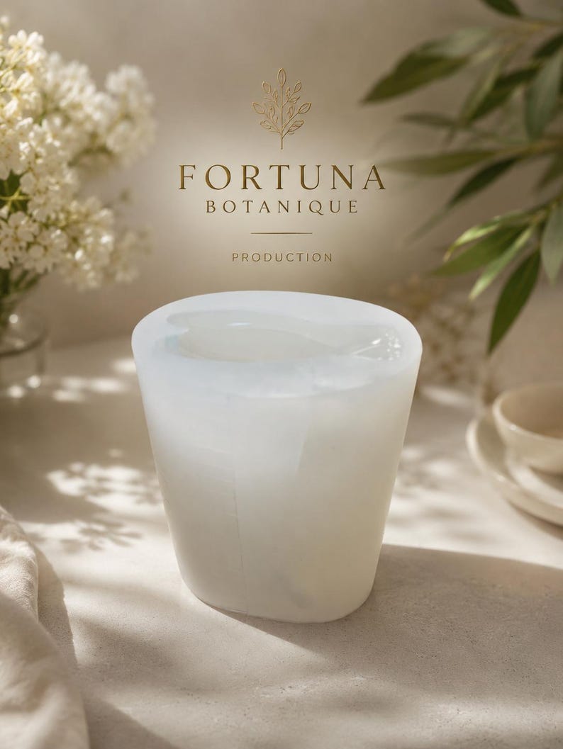 Puede incluir: Un molde de silicona blanco transl&uacute;cido con forma cil&iacute;ndrica y centro hueco. Sobre el molde, el texto FORTUNA BOTANIQUE PRODUCTION est&aacute; impreso en dorado, acompa&ntilde;ado de un peque&ntilde;o icono bot&aacute;nico de l&iacute;neas doradas de una rama.