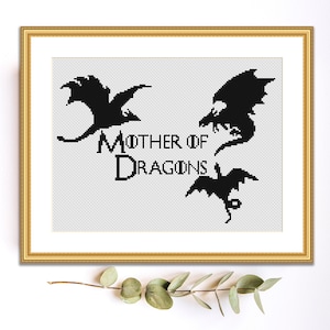 May include: Black and white cross-stitch pattern featuring three dragon silhouettes and the text "Mother of Dragons".