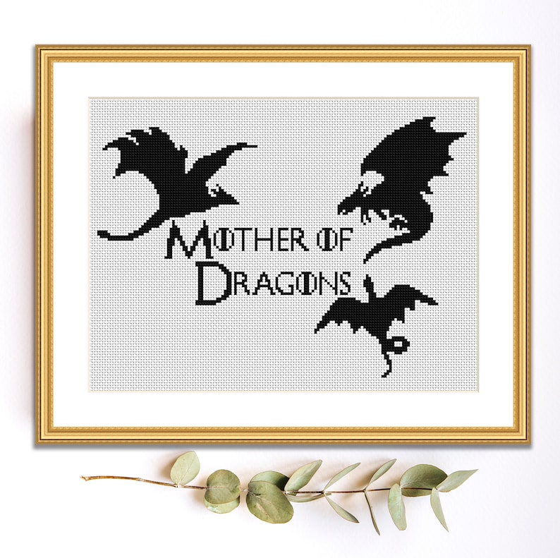 May include: Black and white cross-stitch pattern featuring three dragon silhouettes and the text "Mother of Dragons".