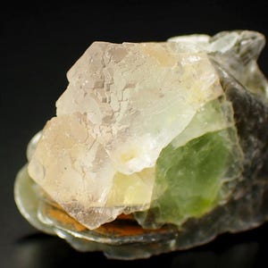 Puede incluir: Un grupo de cristales de fluorita transparentes, verde pálido y blancos. Los cristales son translúcidos y tienen un brillo vítreo. La fluorita es un espécimen mineral natural.