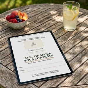 Pode incluir: Um tablet digital exibindo um planejador financeiro pessoal intitulado Mes Finances Sous Contrôle da L'Atelier du Mieux. A tela mostra seções para orçamento, poupança, dívidas e objetivos financeiros, junto com uma citação de Robert Kiyosaki.