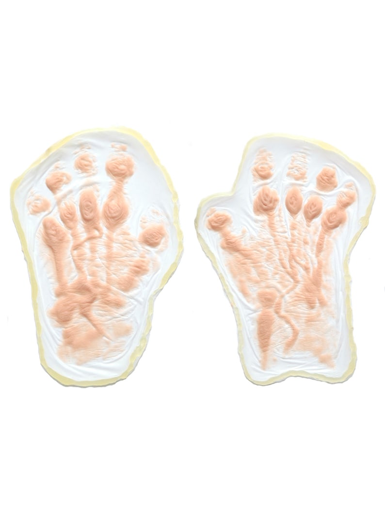 May include: Two beige hand-shaped molds with a textured surface, perfect for creating realistic hand prints for special effects makeup or Halloween costumes.