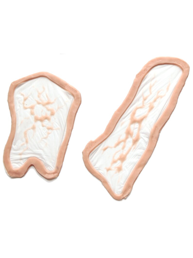 May include: Two silicone moulds for making resin crafts. The moulds are shaped like organic forms with a textured surface. The moulds are light pink in colour.