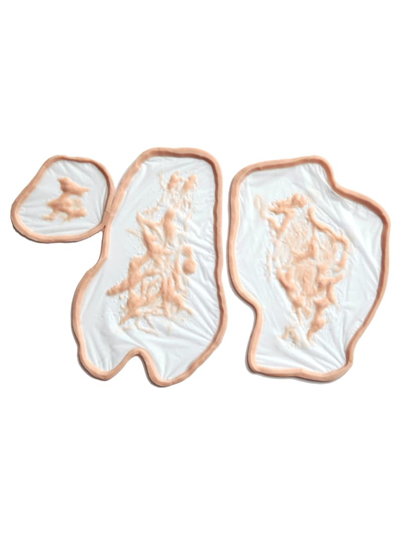 May include: Three prosthetic wound appliances. Each appliance features a flesh-toned border surrounding a white base with a textured, reddish-brown design. The shapes vary, with two larger and one smaller piece.