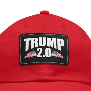 May include: Red baseball cap with a black patch that says "TRUMP 2.0" with two small American flags on either side of the text.