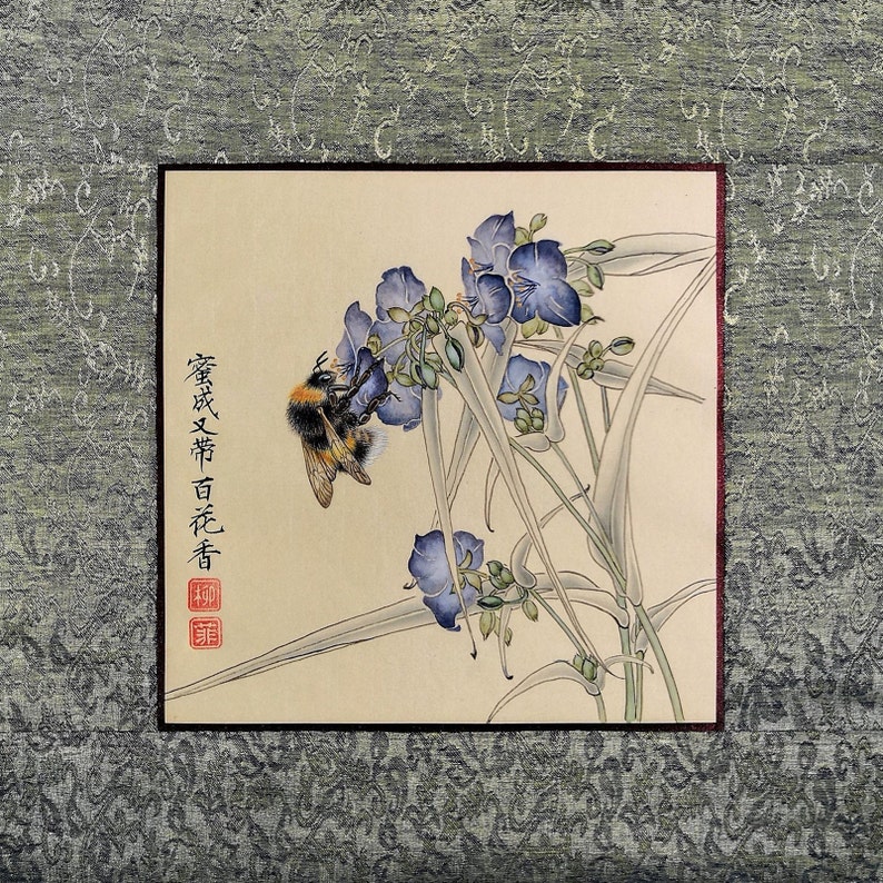 K&ouml;nnte beinhalten: Ein traditionelles chinesisches Gem&auml;lde, das eine Hummel zeigt, die eine Gruppe von lila Bl&uuml;ten best&auml;ubt. Das Gem&auml;lde ist gerahmt und enth&auml;lt den Text "繁花次第百花香" in chinesischen Schriftzeichen.