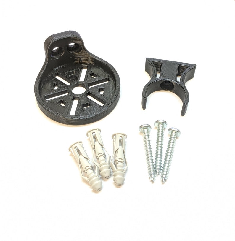 May include: A black plastic wall mount with a circular base and a hook. The mount comes with three white plastic anchors and three silver screws.