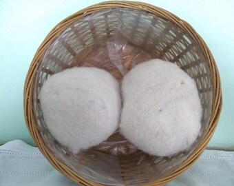 May include: Two large white balls of wool yarn in a brown wicker basket.