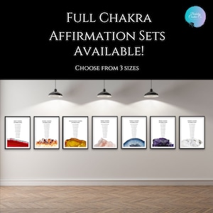 May include: Seven framed prints of chakra affirmations with agate slices in various colours. The prints are displayed on a white wall with three light fixtures above them. The text on the prints reads "Root Chakra Affirmations", "Sacral Chakra Affirmations", "Solar Plexus Chakra Affirmations", "Heart Chakra Affirmations", "Throat Chakra Affirmations", "Third Eye Chakra Affirmations", and "Crown Chakra Affirmations".