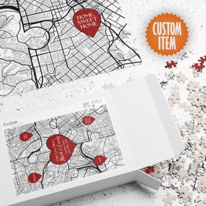 May include: A custom map puzzle with a red heart in the center that says "Our Love Story Mark & Emily" and the date "Together Since June 10, 2019". The puzzle is in a white box with the words "Custom Made" on the side.