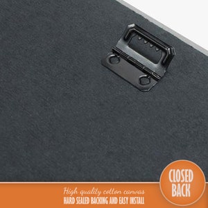 Op de afbeelding: Close-up van de achterkant van een canvas print. De print heeft een zwarte, gestructureerde achterkant en een metalen ophanghaak. De tekst "CLOSED BACK" is in oranje gedrukt op een witte cirkel. De tekst "High quality cotton canvas HARD SEALED BACKING AND EASY INSTALL" is in zwart gedrukt op een oranje achtergrond.