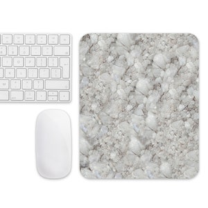 May include: A white mouse and keyboard on a white background with a white and gray marble mousepad.
