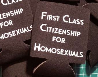 May include: A stack of black foam can coolers with the text "First Class Citizenship for Homosexuals" printed in white on the front.