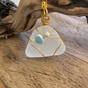 Natural frosted white sea glass pendant.  Gold wrapped with blue freshwater pearl.   Handmade. Unique gift.  Birthstone Gemini.