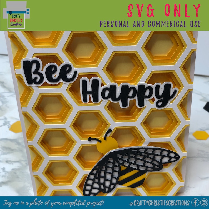 Op de afbeelding: Een digitaal snijbestand met een honingraatpatroon met de tekst "Bee Happy" en een bij-illustratie. Het ontwerp is perfect voor het maken van kaarten, scrapbookpagina's en andere knutselprojecten.