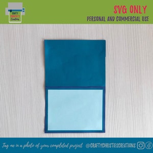 Op de afbeelding: Een teal kaart met een lichtblauw binnenpaneel. De kaart is gesloten en ligt op een houten oppervlak. De tekst "SVG ONLY" en "PERSONAL AND COMMERCIAL USE" is in rood gedrukt bovenaan de afbeelding. De tekst "Tag me in a photo of your completed project @CRAFTYCHRISTIESCREATIONS" is onderaan de afbeelding gedrukt.
