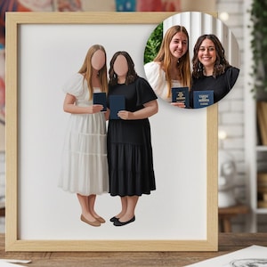 May include: A framed print showing two figures in dresses, holding books. One figure wears a white dress, the other a black dress. A smaller inset image shows the subjects holding books. The frame is light wood.