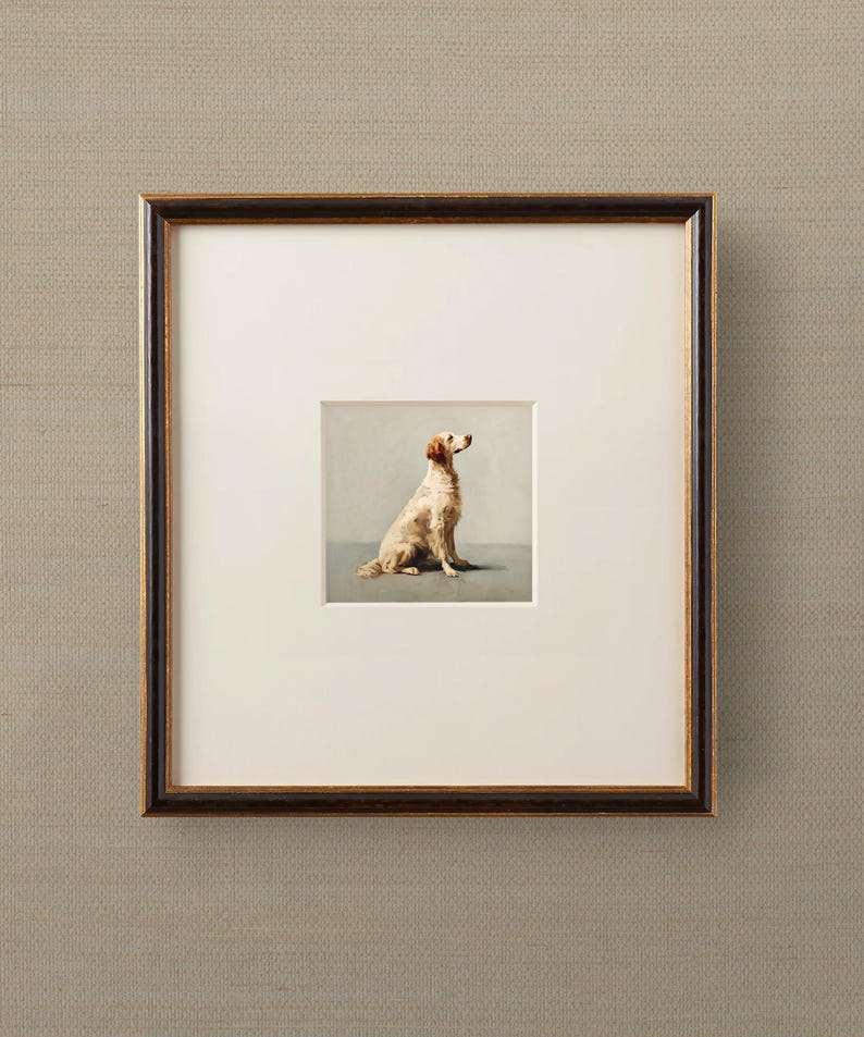 May include: Framed artwork featuring a seated dog with light brown fur, set against a muted gray background. The artwork is matted in white and framed in a dark brown frame with a gold inner edge. The frame is displayed on a textured, neutral-toned wall.