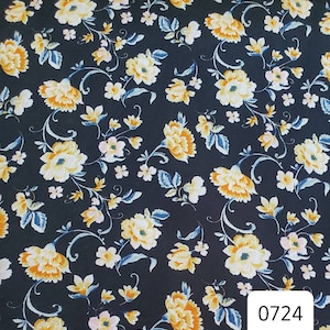 May include: Black fabric with a floral pattern in shades of yellow, white, and blue. The fabric has a small, delicate floral print. The number 0724 is printed in the bottom right corner.