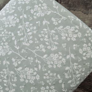 May include: A folded piece of fabric with a light green background and a white floral pattern. The design features delicate white flowers and stems, with a subtle textured effect. The number "2348" is visible in the bottom right corner.