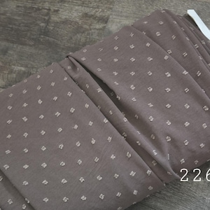 May include: A roll of brown fabric with a repeating pattern of small, raised white squares. The fabric is folded and appears to be a textured material. The number "2263" is printed on the fabric.