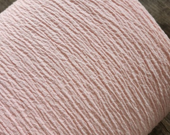 May include: A close-up of a pale pink textured fabric. The fabric has a subtle ribbing pattern. The number 1853 is visible in the bottom right corner of the image.