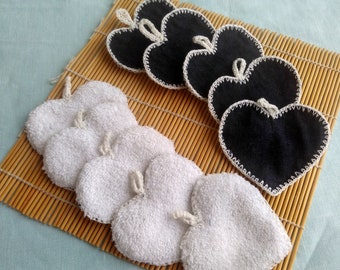 May include: Two sets of heart-shaped reusable makeup remover pads. One set is white and the other is black. Both sets are edged with white crochet.