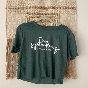 May include: A green cropped t-shirt with the text "I'm speaking - Kamala Harris" in white.