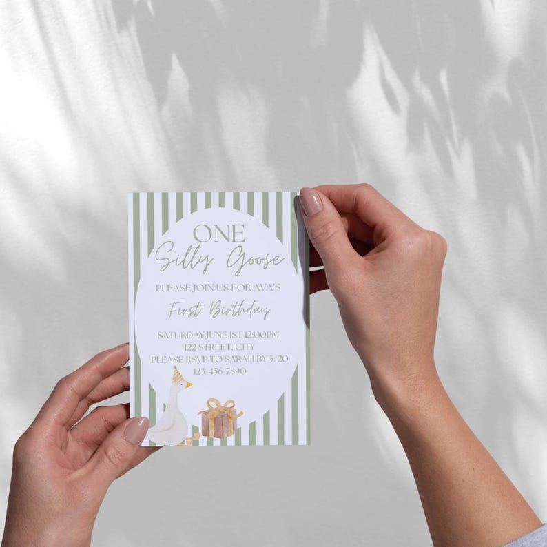 K&ouml;nnte beinhalten: Eine wei&szlig;-gr&uuml;ne gestreifte Einladungskarte mit einer Cartoon-Gans, die einen Partyhut tr&auml;gt und eine Geschenkbox h&auml;lt. Der Text auf der Karte lautet "ONE Silly Goose Please join us for Ava's First Birthday Saturday June 1st 12:00pm 122 Street, City Please RSVP to Sarah by 5/20 123-456-7890".