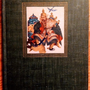 May include: A green book cover with a gold frame around a colorful illustration of a man in a crown sitting on a throne. The man is holding a sword and a bird is flying above him.